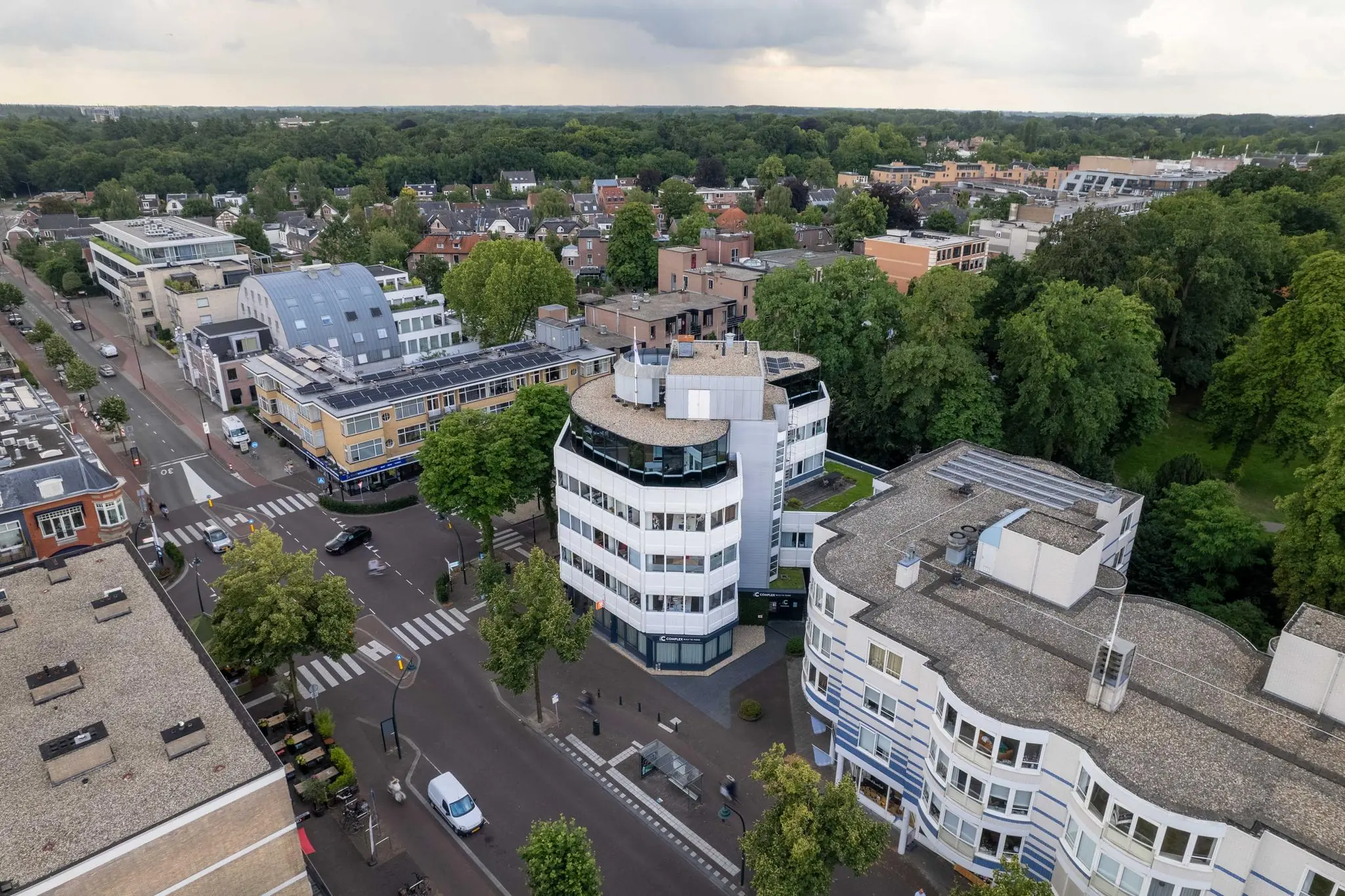 Luchtfoto van de 1e Hogeweg in Zeist met moderne kantoorpanden, woongebouwen en omliggend groen.